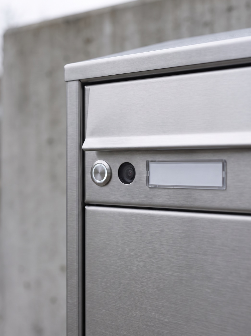 Detailaufnahme einer Briefkastenanlage mit Klingel und Namensschild