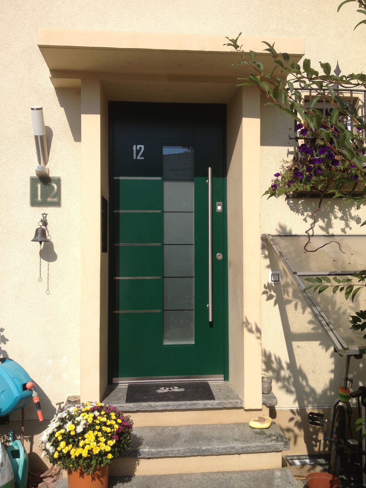 Grüne Haustür mit Edelstahl-Lisenen